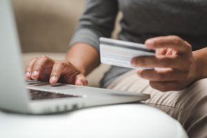 Internet shopper entering credit card information using laptop keyboard